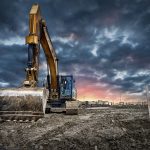 Excavator,Machinery,At,Construction,Site,,Sunset,In,Background.